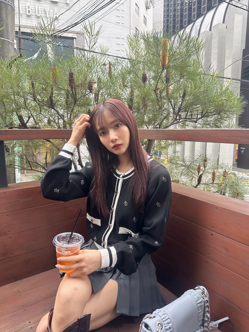 ブラック系のアンサンブル、ブルー系のショルダーバッグを着用したレディースの冬コーディネートの2枚目の写真