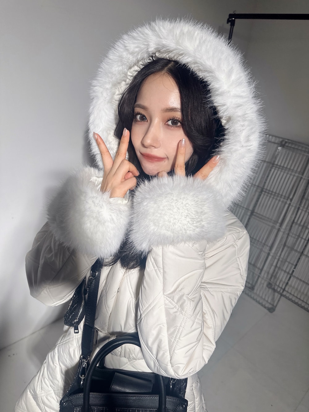 ホワイト系のダウンジャケット/コート、グレー系のショルダーバッグを着用したレディースの冬コーディネートの3枚目の写真