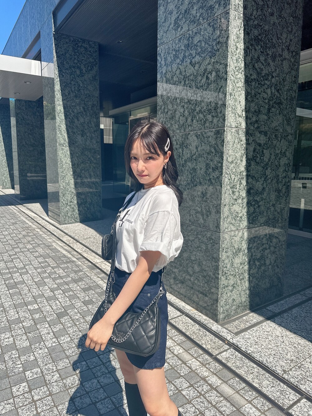 ホワイト系のTシャツ/カットソー、ブラック系のショルダーバッグを着用したレディースの夏コーディネートの3枚目の写真