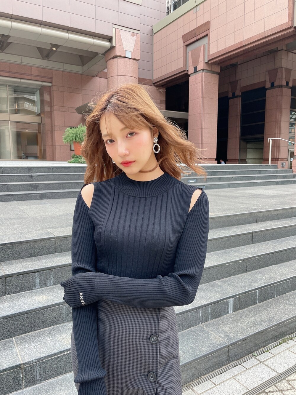 ブラック系のスカート、ブラック系のニット/セーター、ブラック系のブーツを着用したレディースの秋コーディネートの5枚目の写真