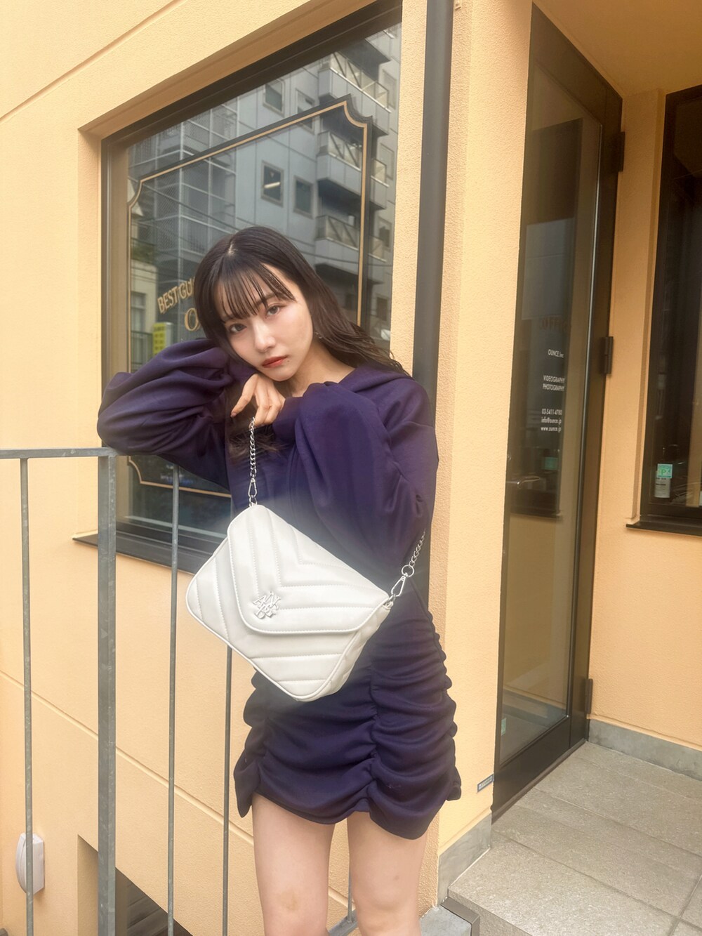 ブルー系のワンピース、ホワイト系のショルダーバッグを着用したレディースの春コーディネートの2枚目の写真