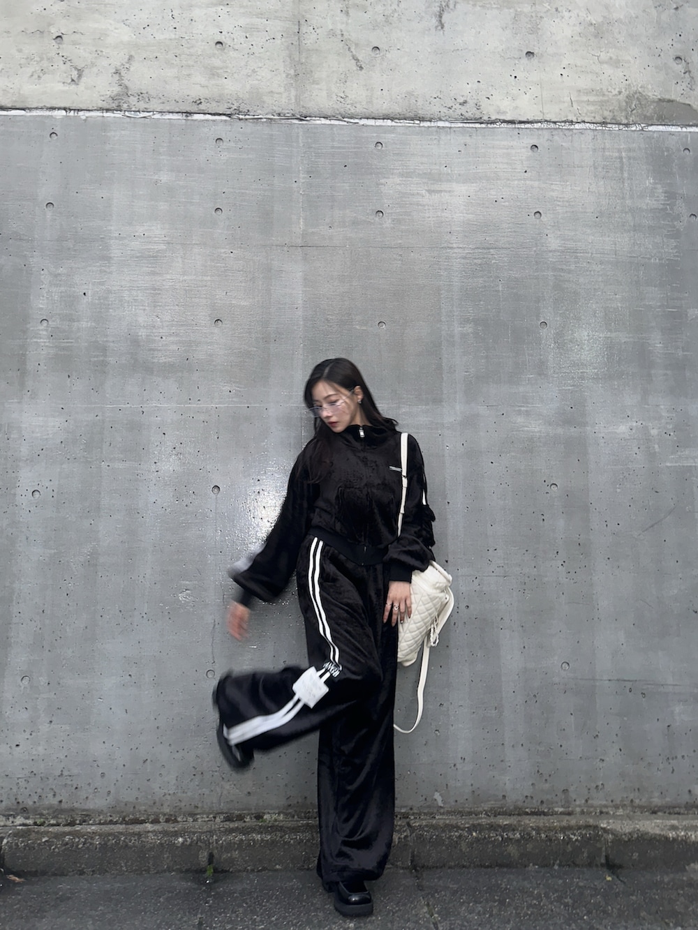 ブラック系のジャージ、ホワイト系のバックパック/リュックを着用したレディースの冬コーディネートの5枚目の写真