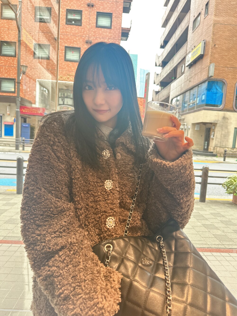 ブラウン系のダウンジャケット/コート、ブラック系のトートバッグを着用したレディースの春コーディネートの3枚目の写真