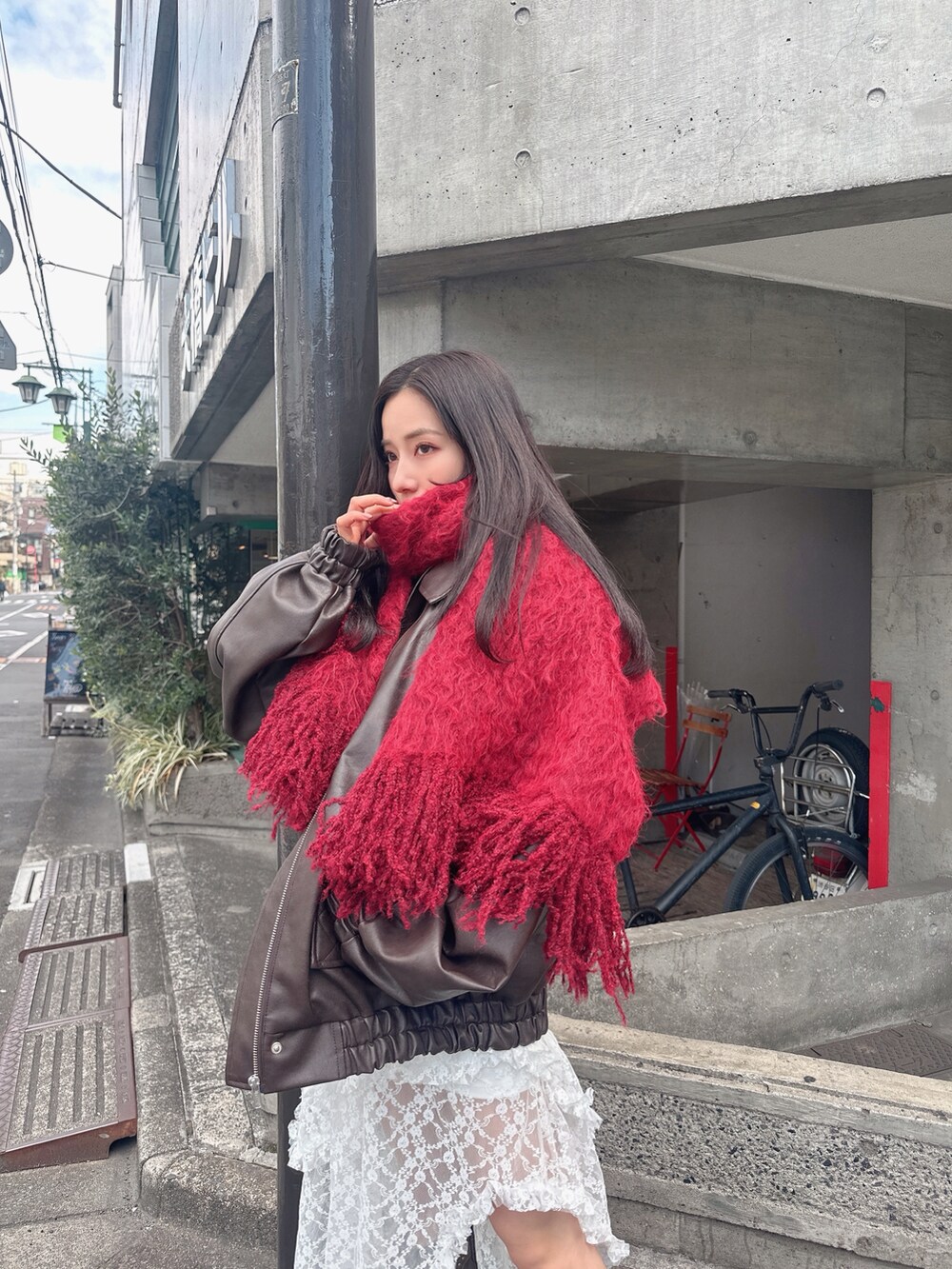 ブラウン系のブルゾン、ホワイト系のスカートを着用したレディースの夏コーディネートの2枚目の写真