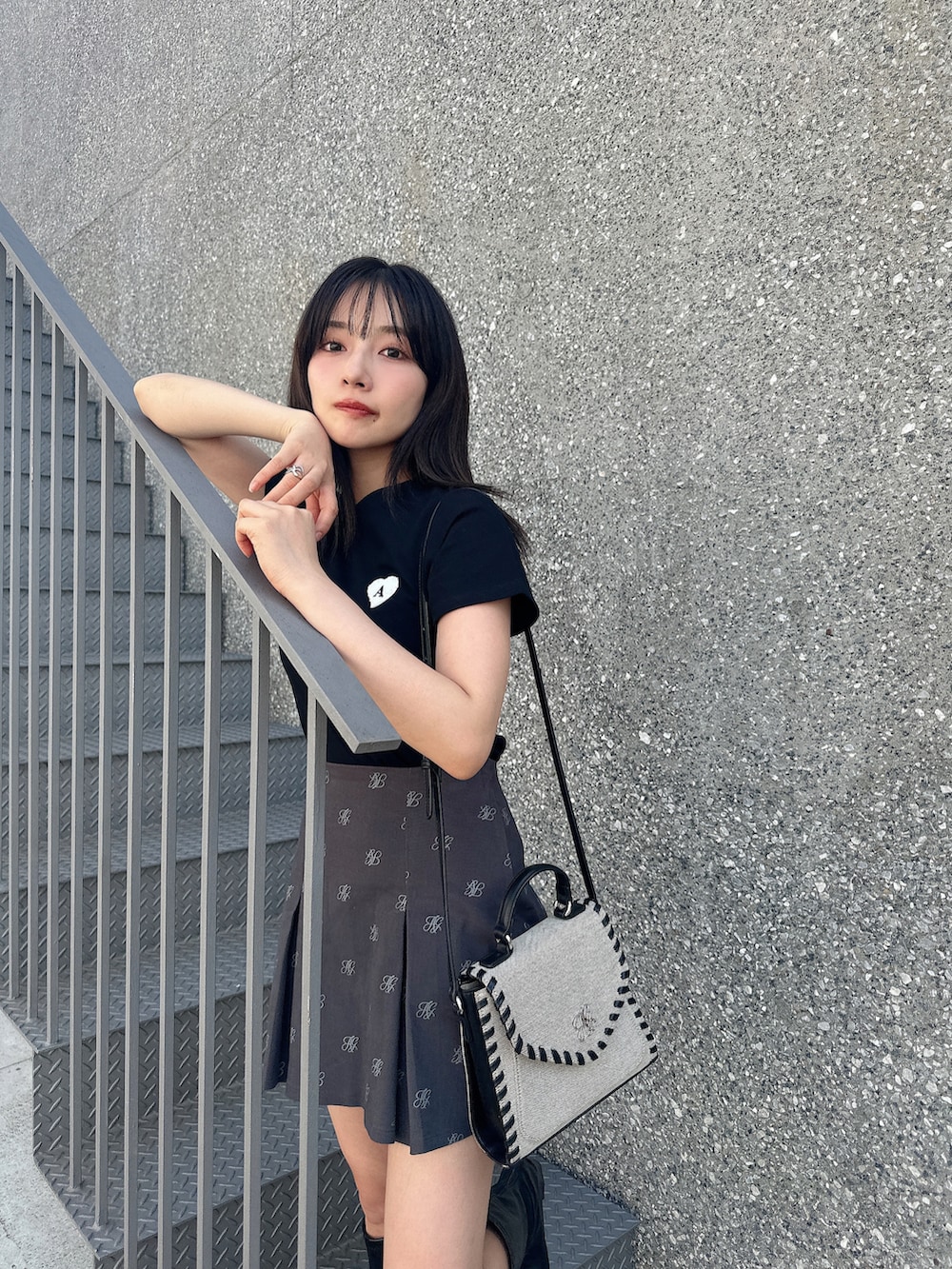 ブラック系のTシャツ/カットソー、グレー系のスカート、ベージュ系のショルダーバッグを着用したレディースの夏コーディネートの4枚目の写真