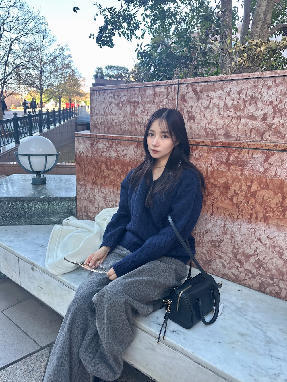 ブラック系のトートバッグを着用したレディースの冬コーディネートの2枚目の写真