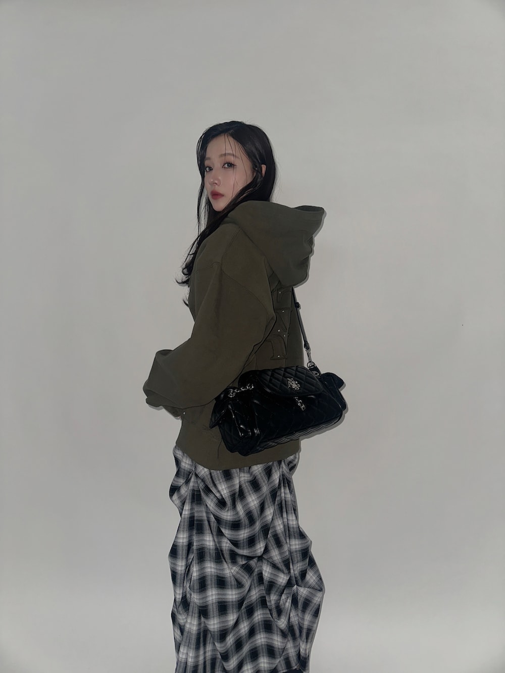 グリーン系のパーカー、ブラック系のバックパック/リュック、ブラック系のスカートを着用したレディースの冬コーディネートの2枚目の写真