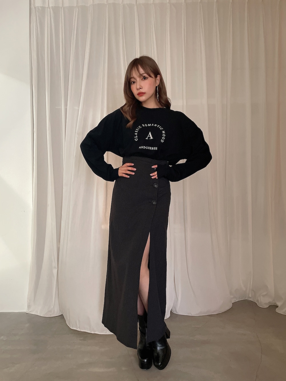 ブラック系のTシャツ/カットソー、ブラック系のブーツ、ブラック系のスカートを着用したレディースの秋コーディネートの2枚目の写真