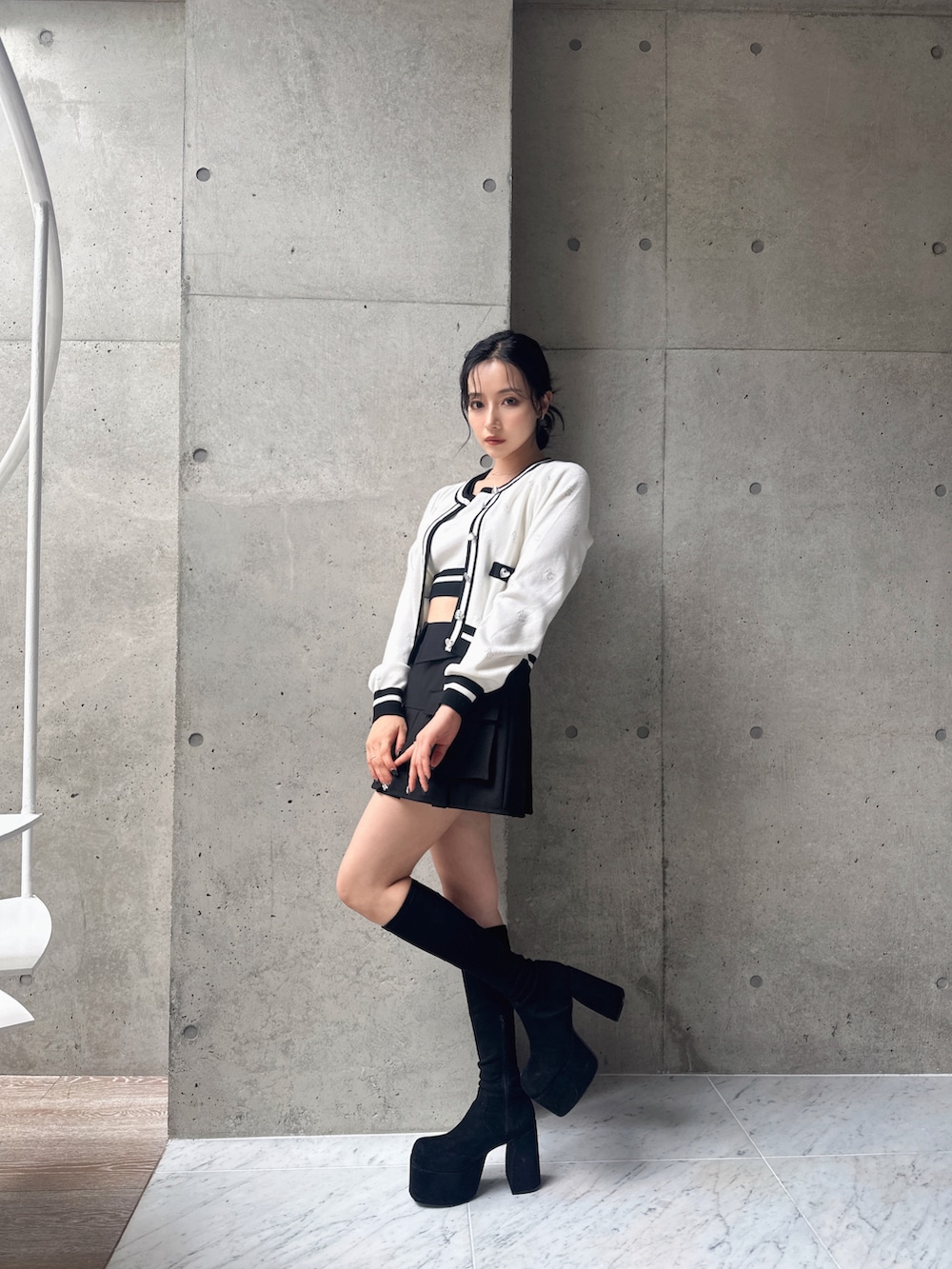 ホワイト系のアンサンブル、ブラック系のスカートを着用したレディースの秋コーディネートの4枚目の写真