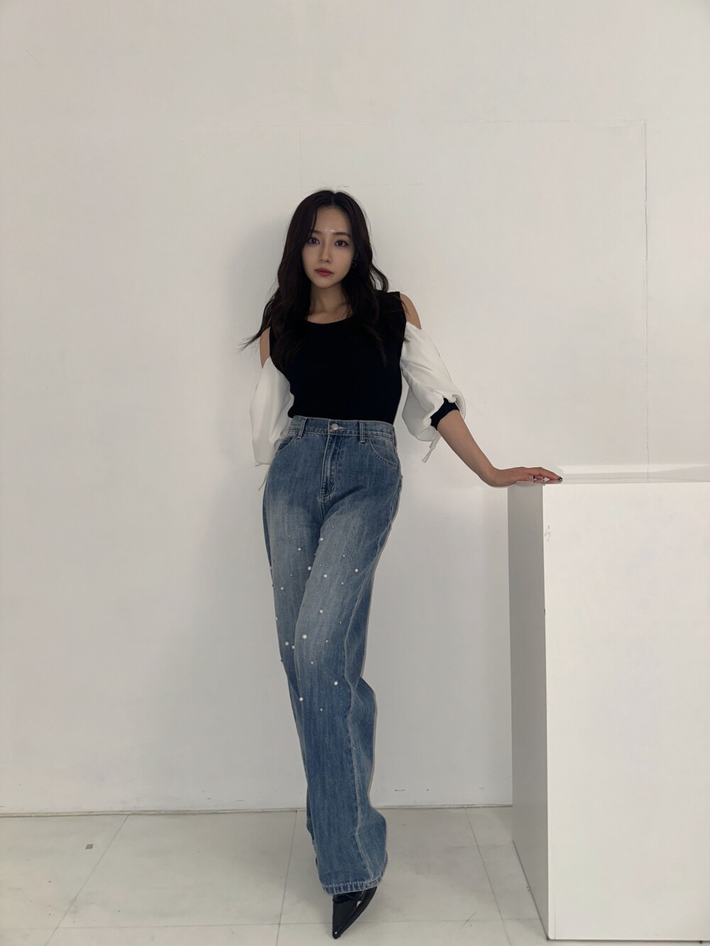 ブラック系のその他トップス、ブルー系のデニムパンツを着用したレディースの秋コーディネートの2枚目の写真