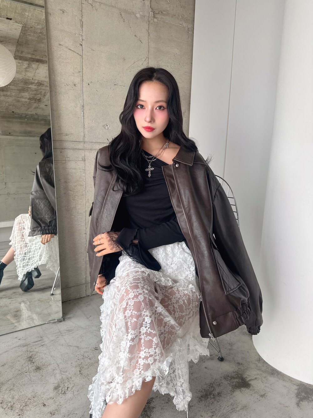 ブラウン系のブルゾン、ブラック系のTシャツ/カットソー、ホワイト系のスカートを着用したレディースの春コーディネートの5枚目の写真