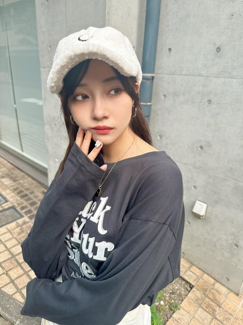 グレー系のTシャツ/カットソー、ホワイト系のキャップを着用したレディースの冬コーディネートの2枚目の写真