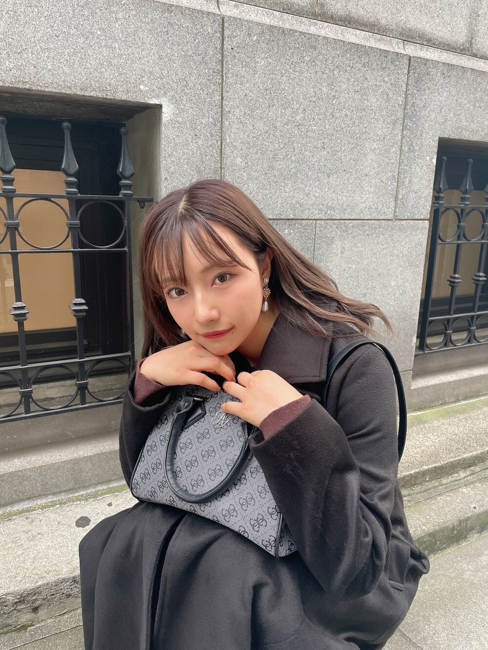 ブラック系のチェスターコート、ブラック系のブーツを着用したレディースの冬コーディネートの5枚目の写真