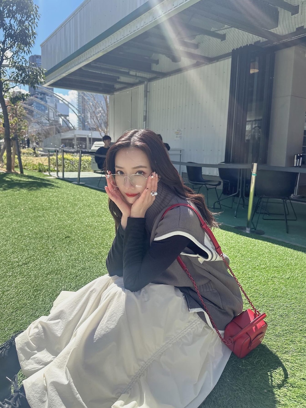 グレー系のベスト、ホワイト系のスカートを着用したレディースの夏コーディネートの5枚目の写真