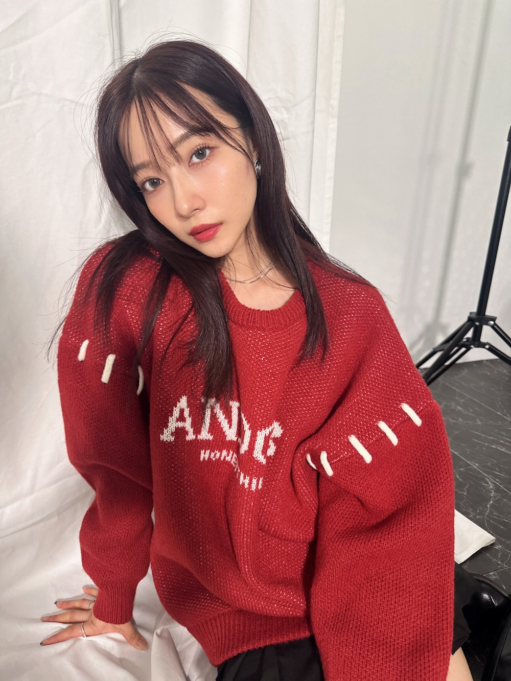 レッド系のニット/セーターを着用したレディースの冬コーディネートの4枚目の写真