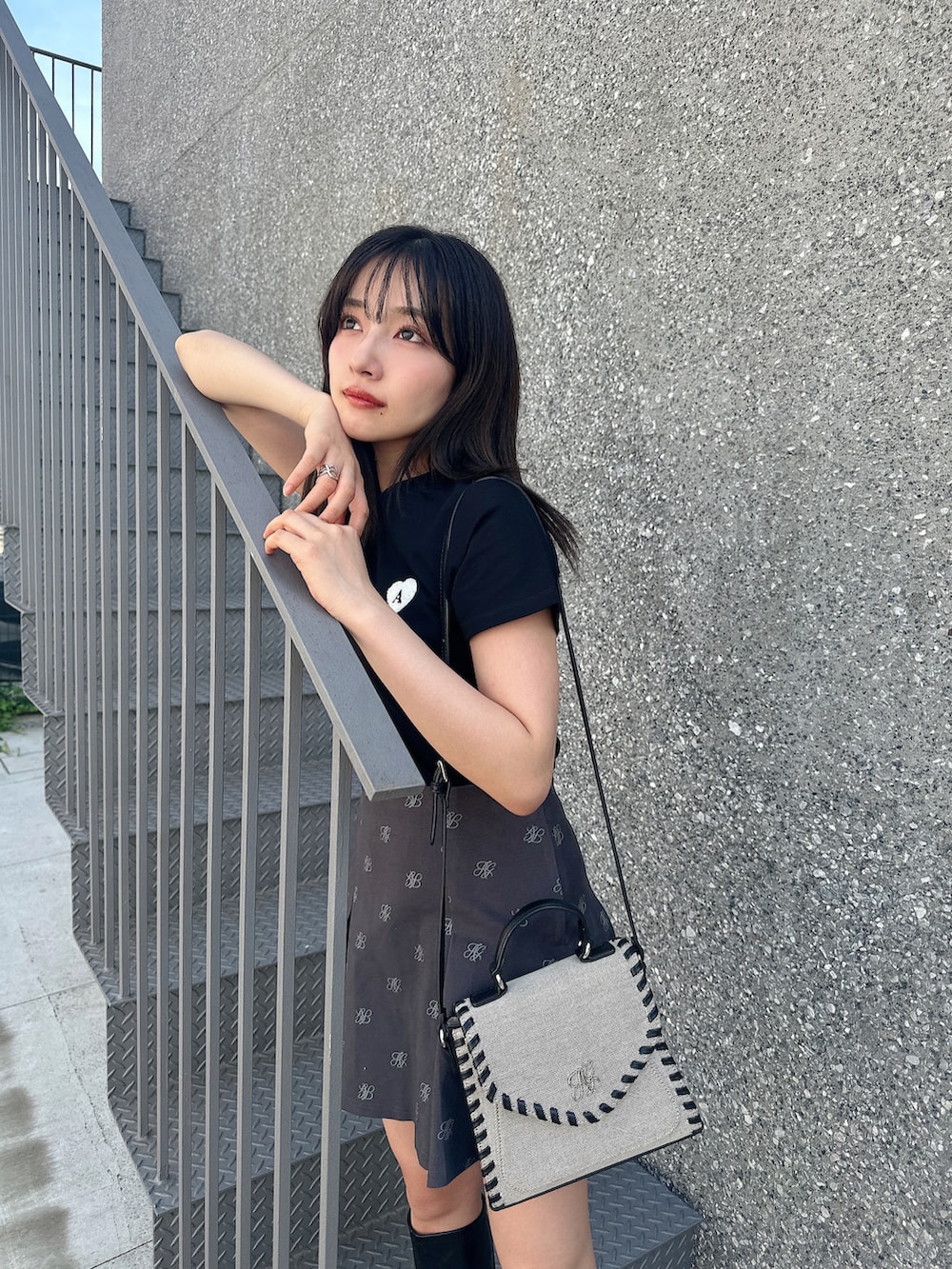 ブラック系のTシャツ/カットソー、グレー系のスカート、ベージュ系のショルダーバッグを着用したレディースの夏コーディネートの3枚目の写真