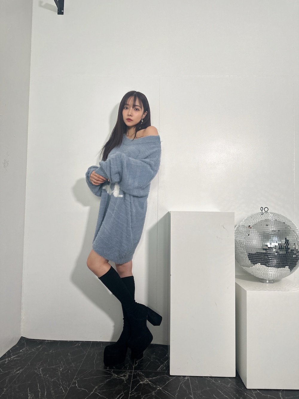 ブルー系のニット/セーターを着用したレディースの冬コーディネートの3枚目の写真