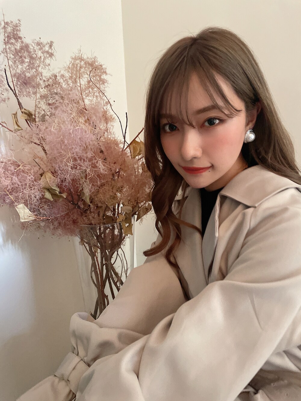 グレー系のトレンチコートを着用したレディースの秋コーディネートの3枚目の写真