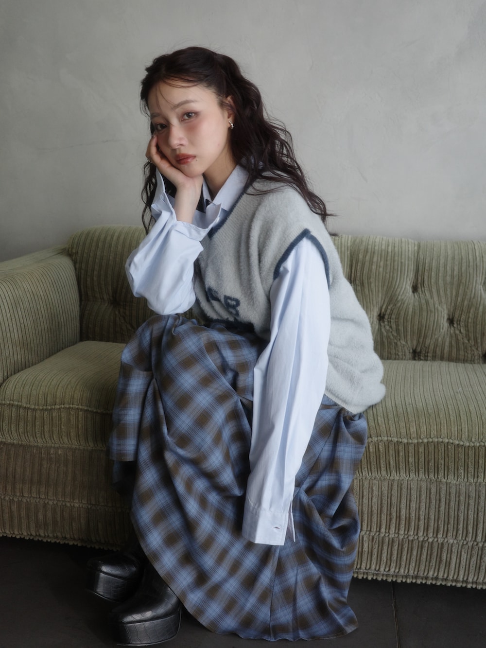 グレー系のベスト、ブルー系のシャツ/ブラウス、ブルー系のスカートを着用したレディースの秋コーディネートの2枚目の写真