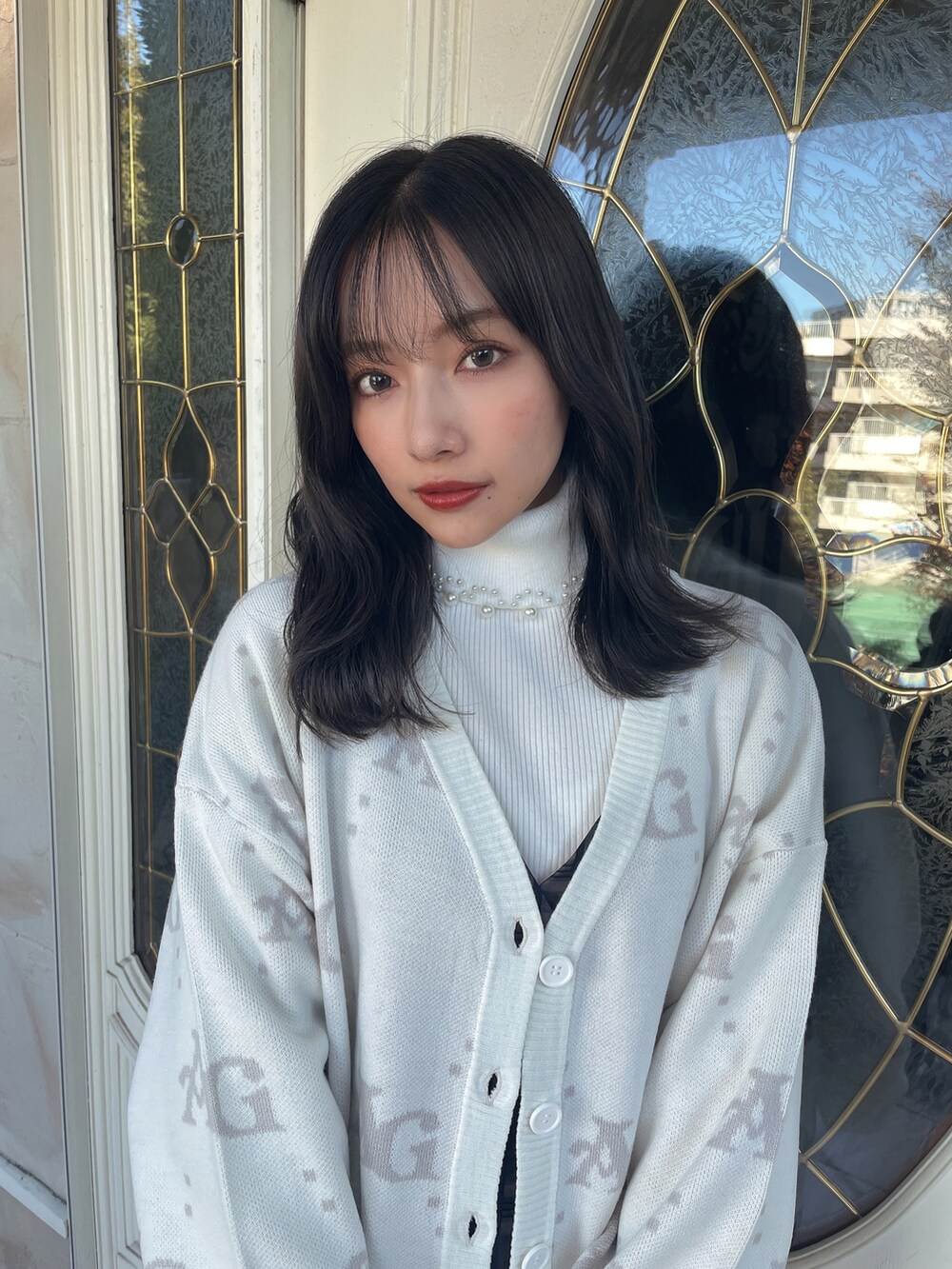 ブラック系のワンピース、ホワイト系のニット/セーターを着用したレディースの春コーディネートの4枚目の写真