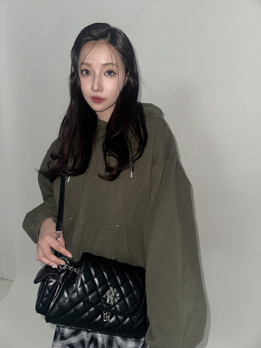 グリーン系のパーカー、ブラック系のバックパック/リュック、ブラック系のスカートを着用したレディースの冬コーディネートの3枚目の写真