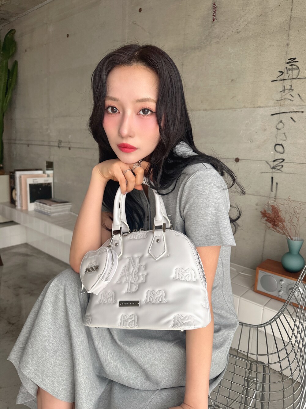 グレー系のワンピース、グレー系のショルダーバッグを着用したレディースの春コーディネートの2枚目の写真