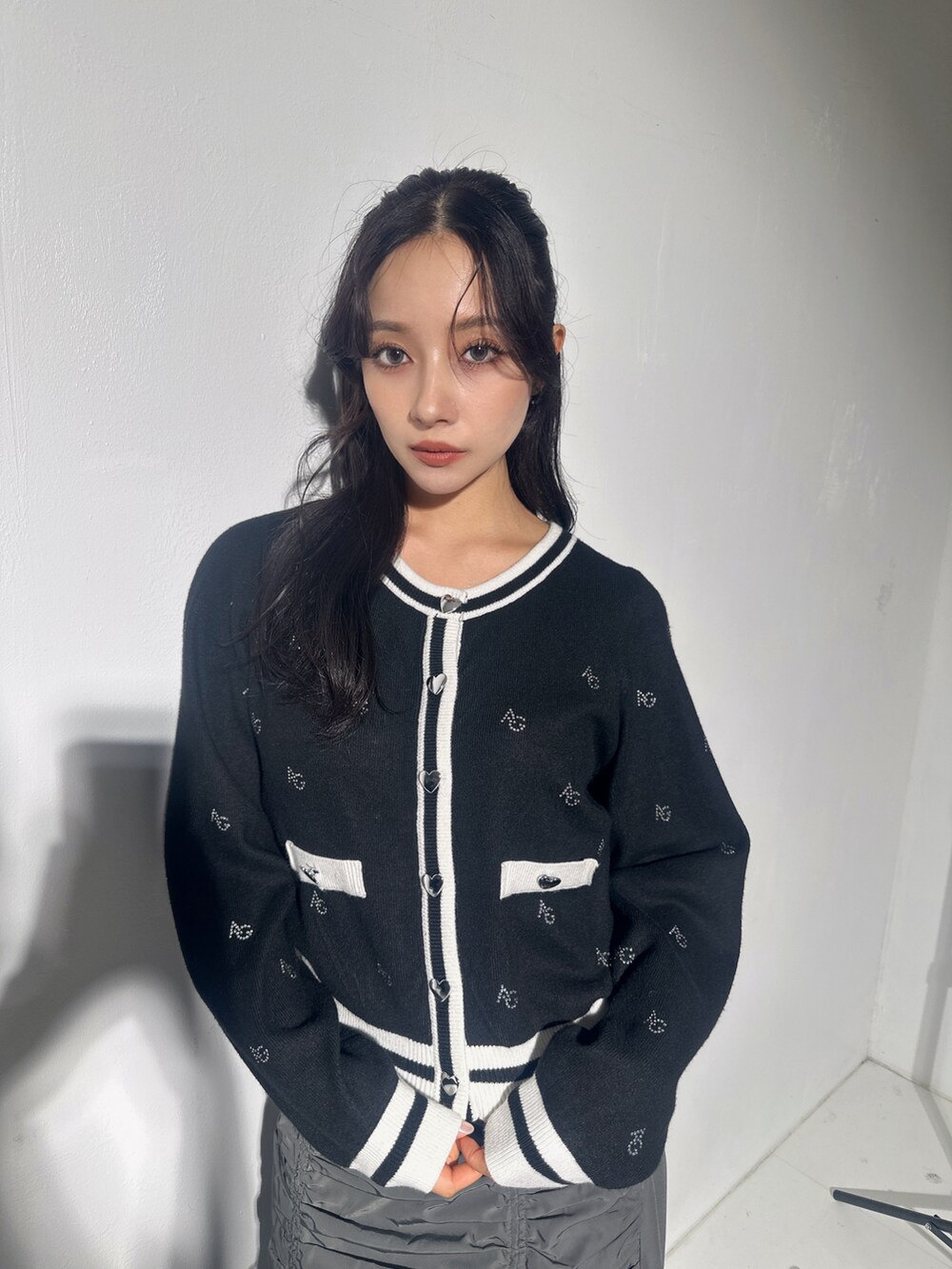 ブラック系のアンサンブル、グレー系のスカートを着用したレディースの冬コーディネートの2枚目の写真