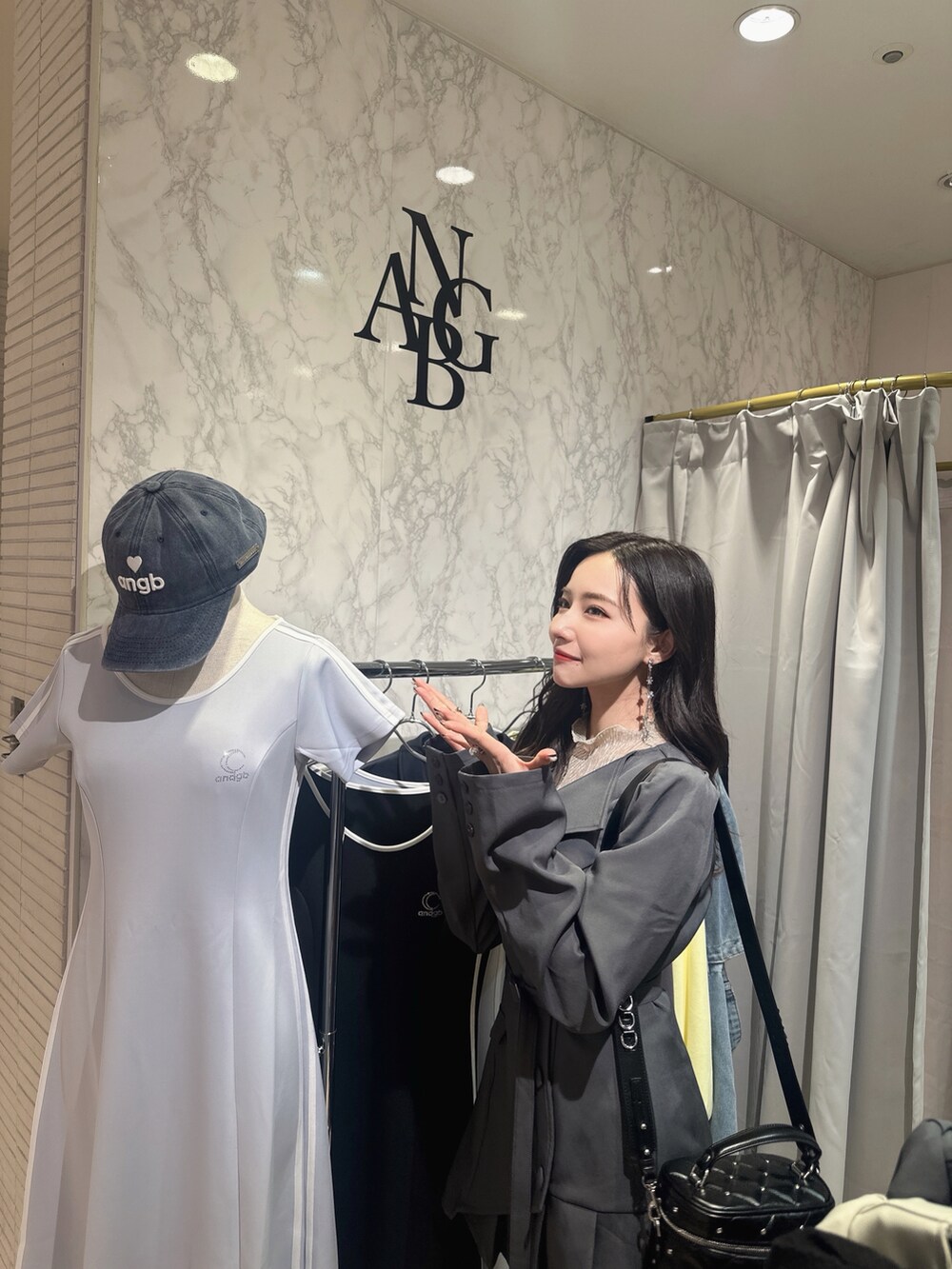 グレー系のワンピースを着用したレディースの夏コーディネートの2枚目の写真