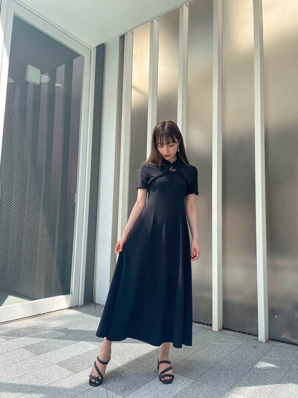 ブラック系のワンピースを着用したレディースの夏コーディネートの2枚目の写真