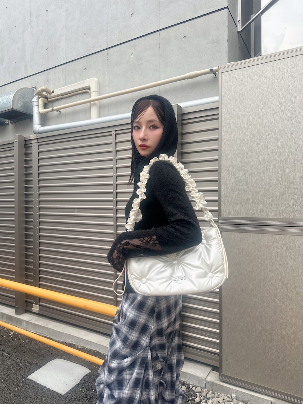 ブラック系のニット/セーター、ブルー系のスカート、ホワイト系のショルダーバッグを着用したレディースの秋コーディネートの3枚目の写真