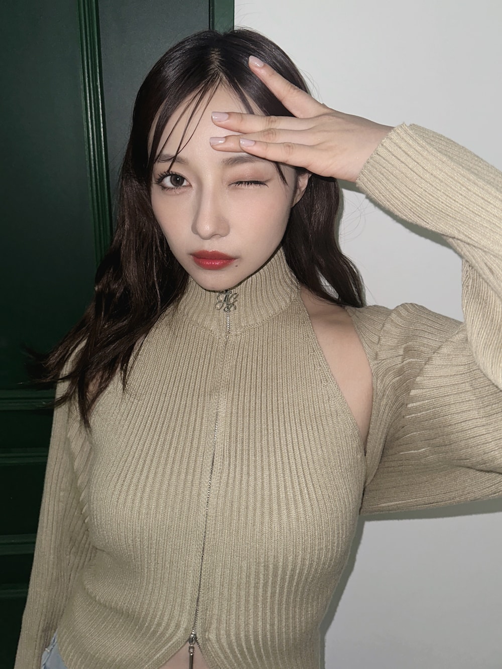 グリーン系のニット/セーターを着用したレディースの秋コーディネートの2枚目の写真