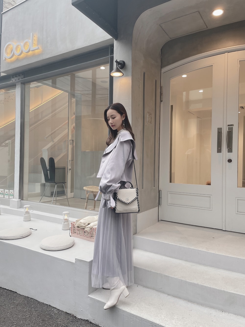 グレー系のトレンチコート、グレー系のワンピースを着用したレディースの夏コーディネートの2枚目の写真
