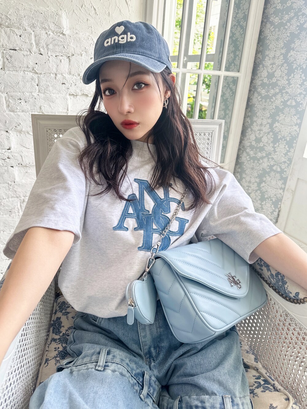 ブルー系のショルダーバッグ、グレー系のTシャツ/カットソー、ブルー系のキャップを着用したレディースの夏コーディネートの3枚目の写真