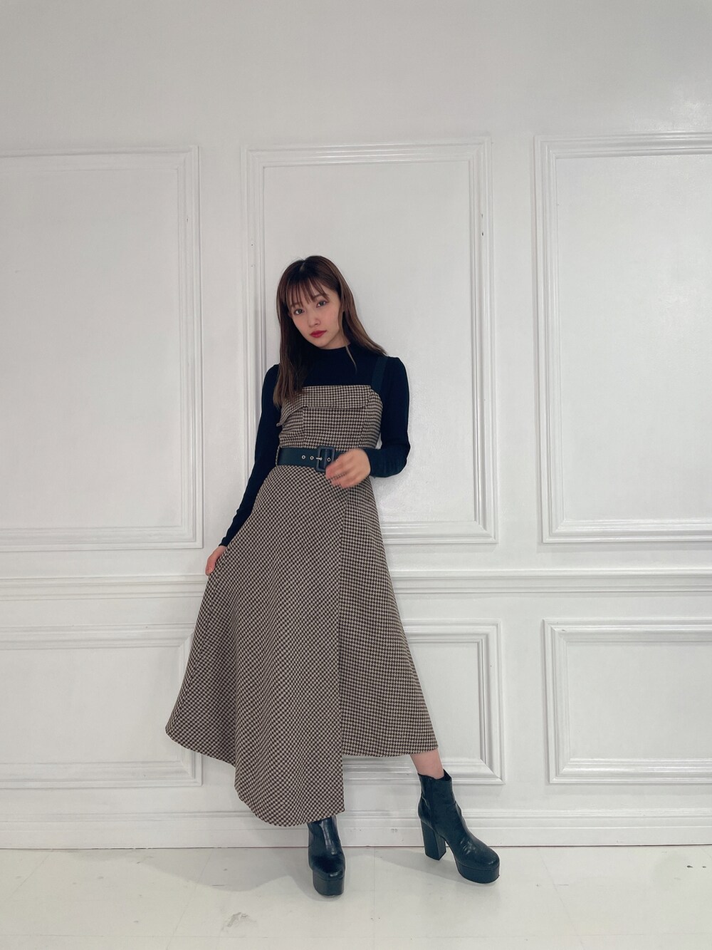 ブラウン系のワンピース、ブラック系のブーツを着用したレディースの冬コーディネートの3枚目の写真