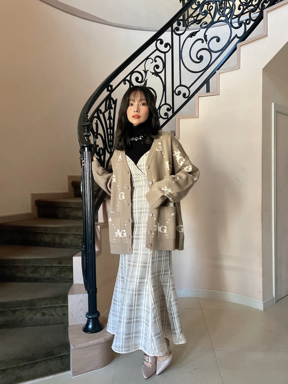 ブラック系のワンピース、ブラウン系のカーディガン/ボレロ、ブラック系のニット/セーターを着用したレディースの春コーディネートの2枚目の写真