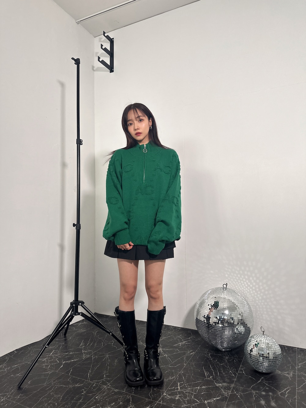 グリーン系のニット/セーターを着用したレディースの冬コーディネートの2枚目の写真