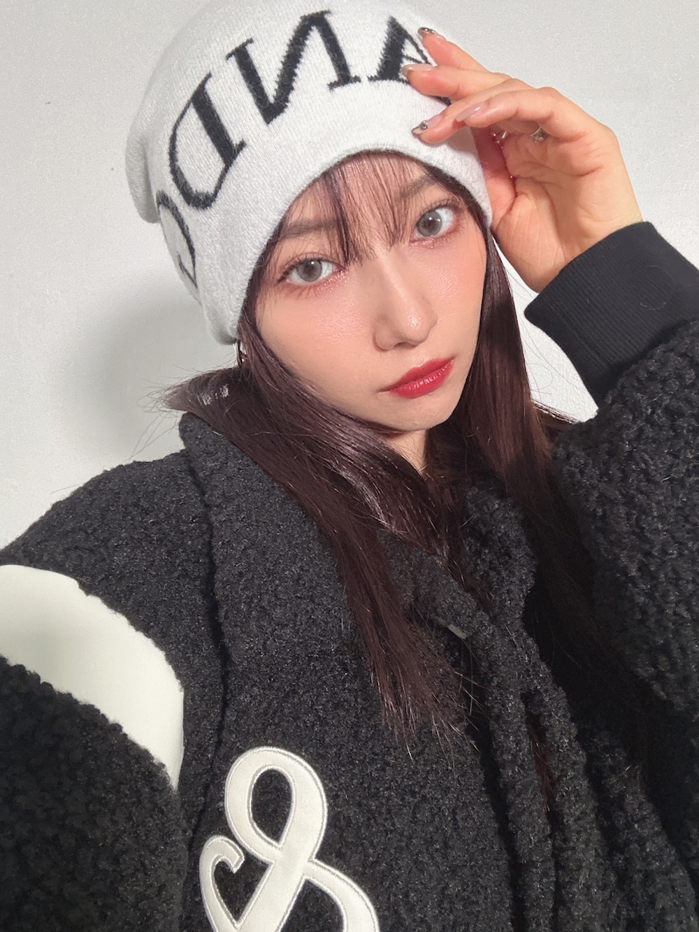 ブラック系のスタジャン、ホワイト系のニットキャップ/ビーニーを着用したレディースの冬コーディネートの2枚目の写真