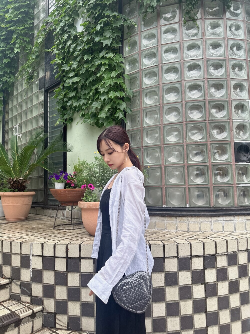 ブラック系のショルダーバッグ、ブラック系のワンピースを着用したレディースの夏コーディネートの4枚目の写真