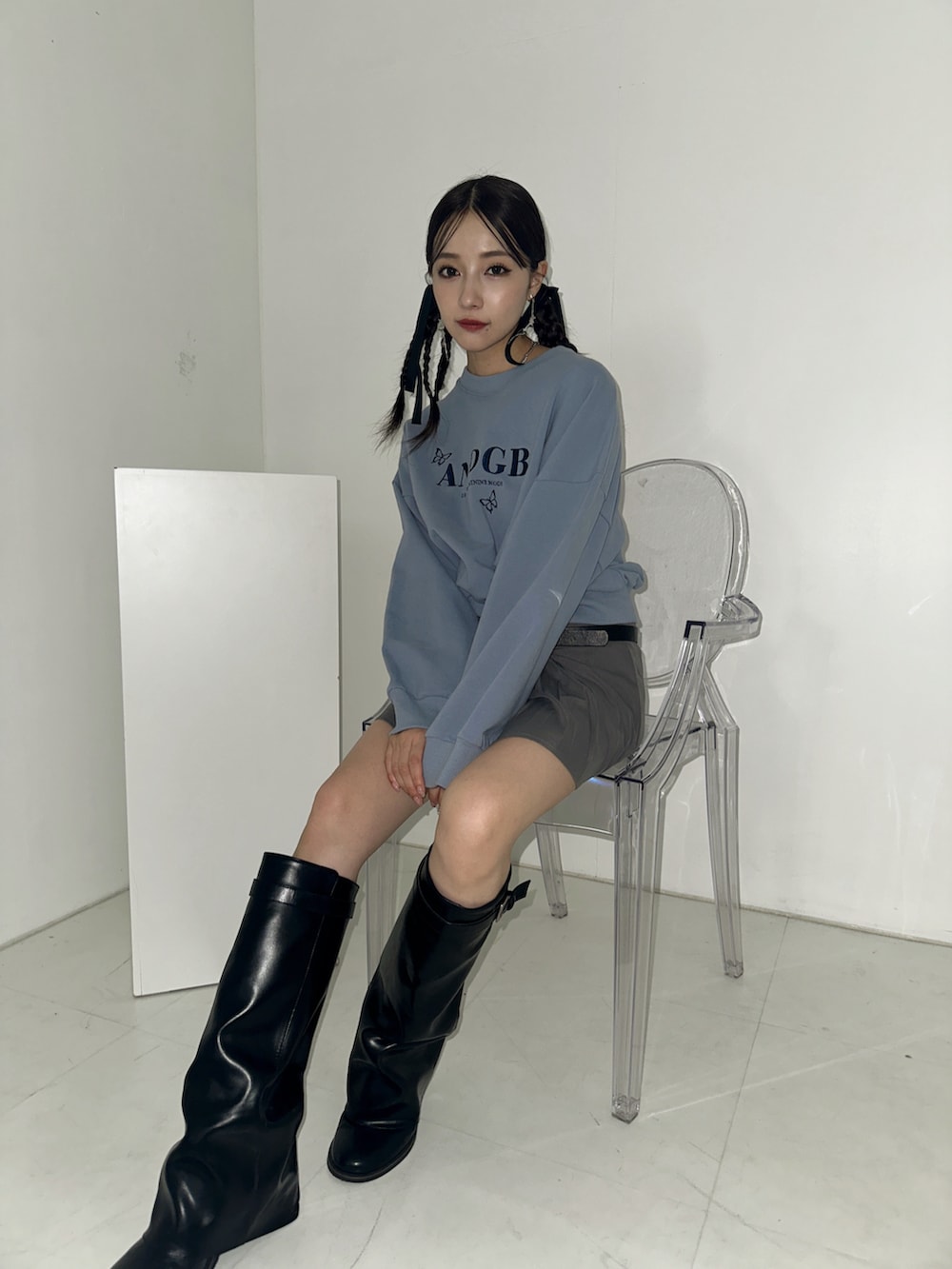 ホワイト系のスウェット、ブラック系のブーツを着用したレディースの冬コーディネートの2枚目の写真