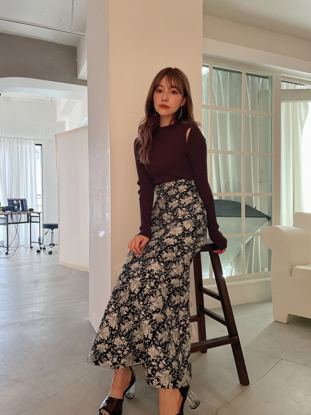 ブラック系のスカート、ブラック系のサンダル、ブラウン系のニット/セーターを着用したレディースの秋コーディネートの2枚目の写真