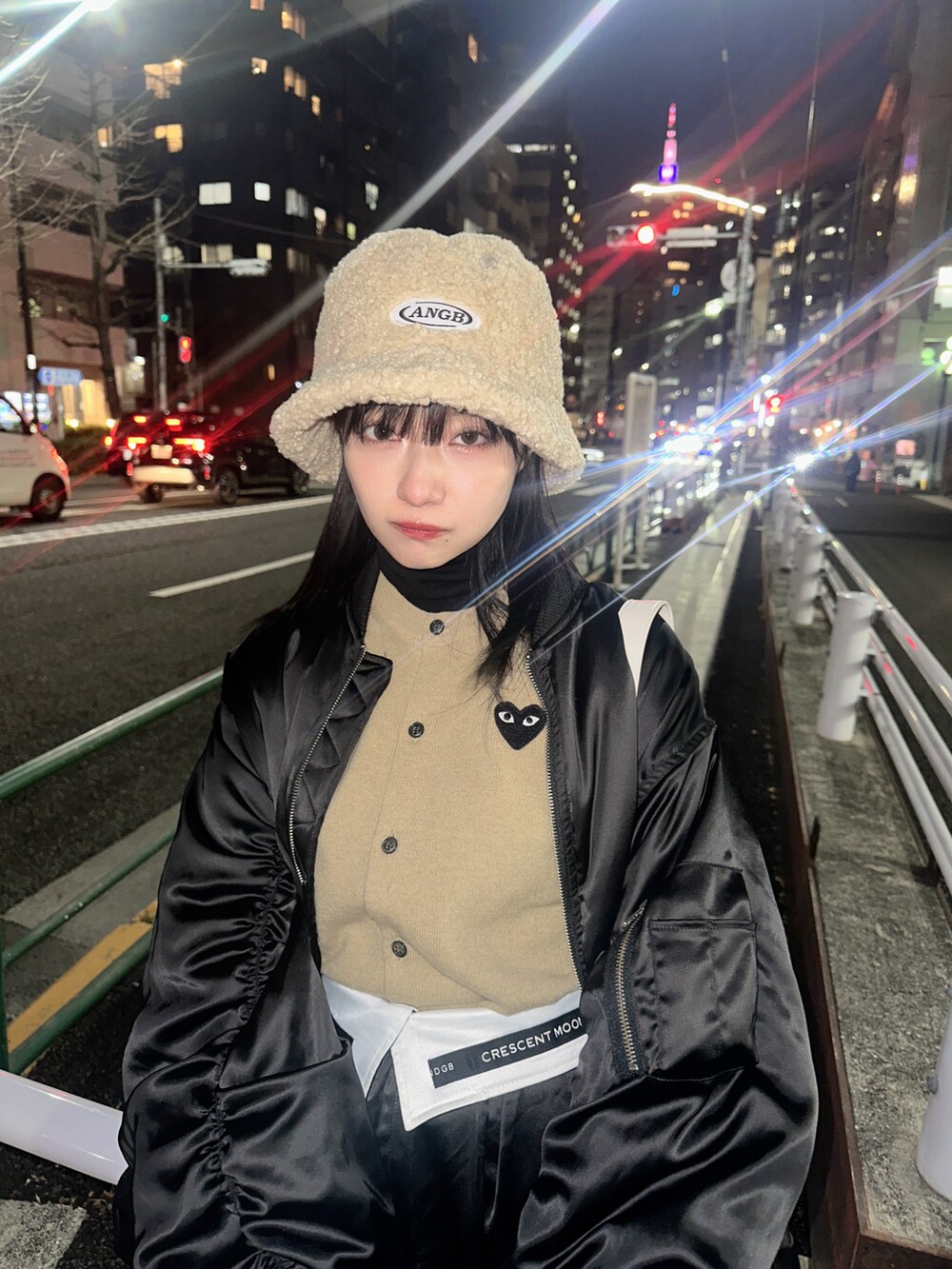 ブラック系のブルゾン、ホワイト系のショルダーバッグ、ブルー系のニット/セーターを着用したレディースの春コーディネートの3枚目の写真