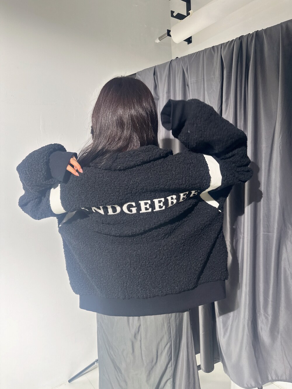 ブラック系のスタジャン、グレー系のスカートを着用したレディースの冬コーディネートの2枚目の写真