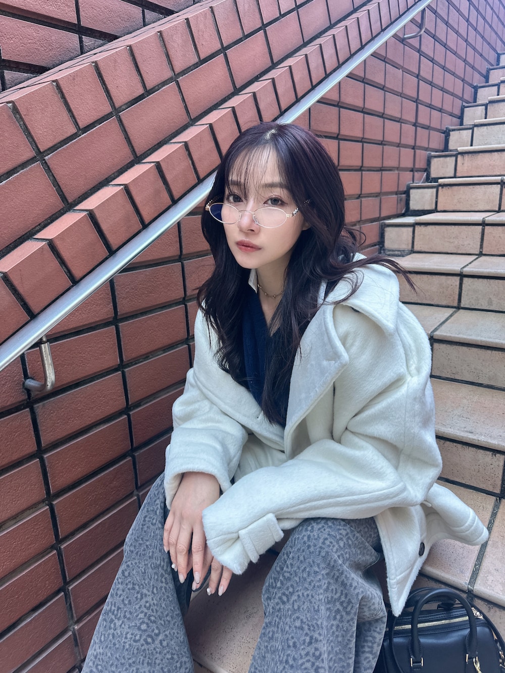 ブラック系のトートバッグを着用したレディースの冬コーディネートの3枚目の写真