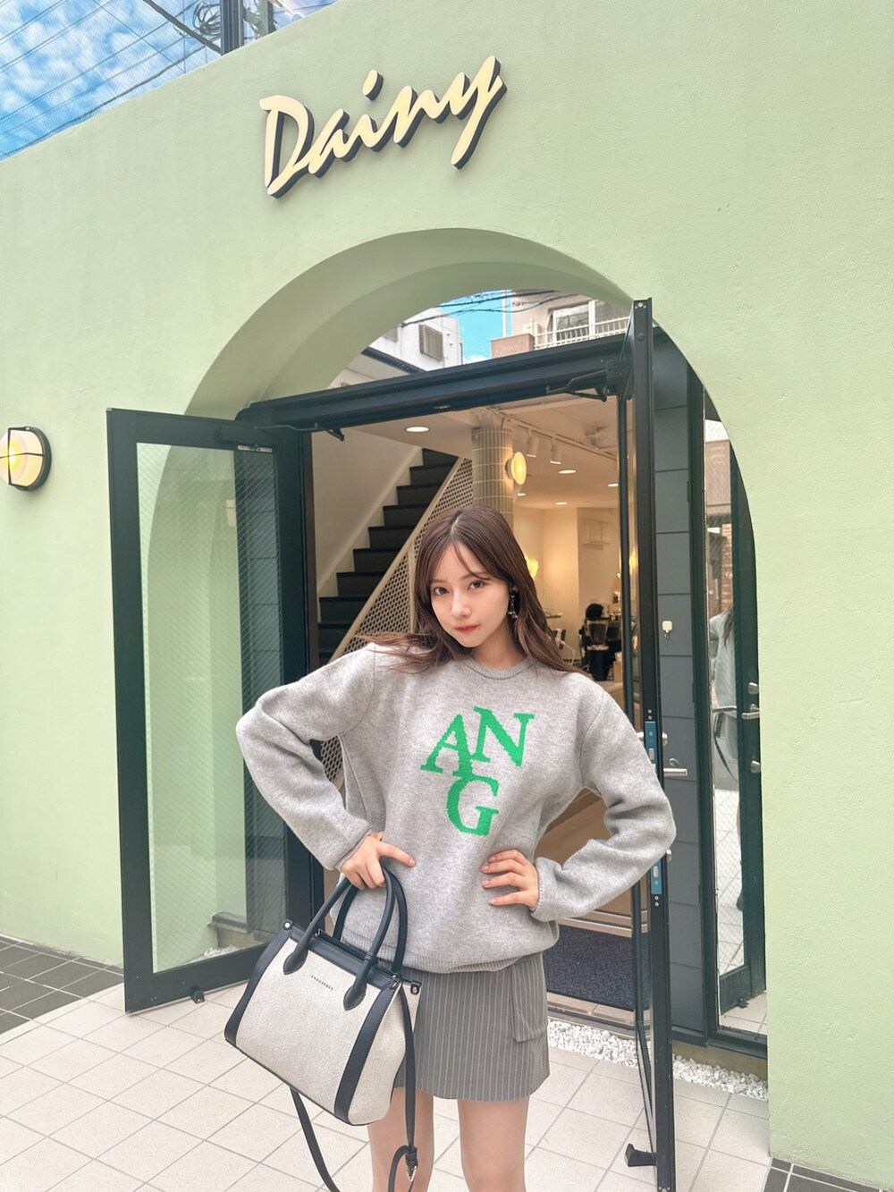 ブルー系のニット/セーター、ブラック系のショルダーバッグを着用したレディースの冬コーディネートの5枚目の写真