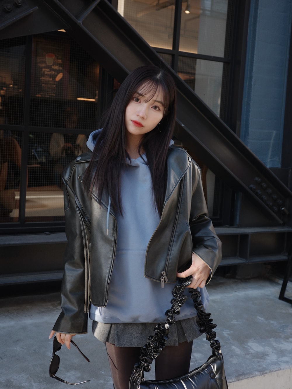 ブルー系のパーカー、ブラック系のショルダーバッグを着用したレディースの春コーディネートの3枚目の写真