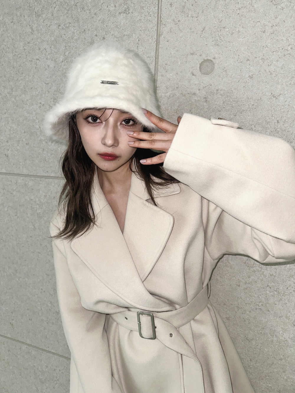 ベージュ系のダウンジャケット/コート、ホワイト系のハットを着用したレディースの冬コーディネートの3枚目の写真