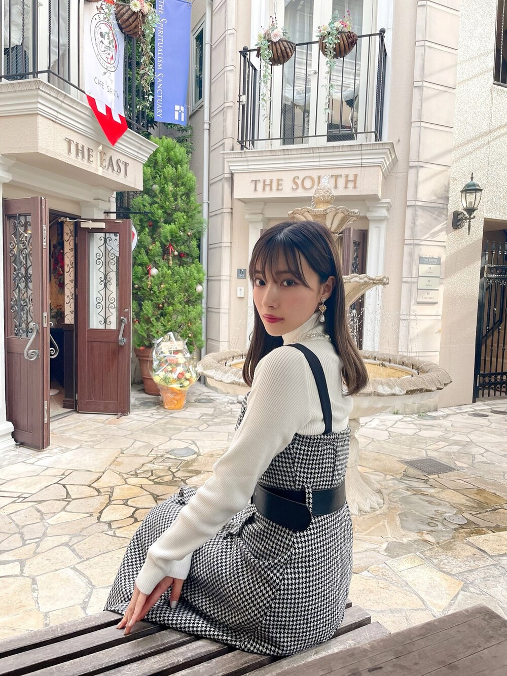 ホワイト系のニット/セーター、ブラック系のワンピースを着用したレディースの春コーディネートの2枚目の写真