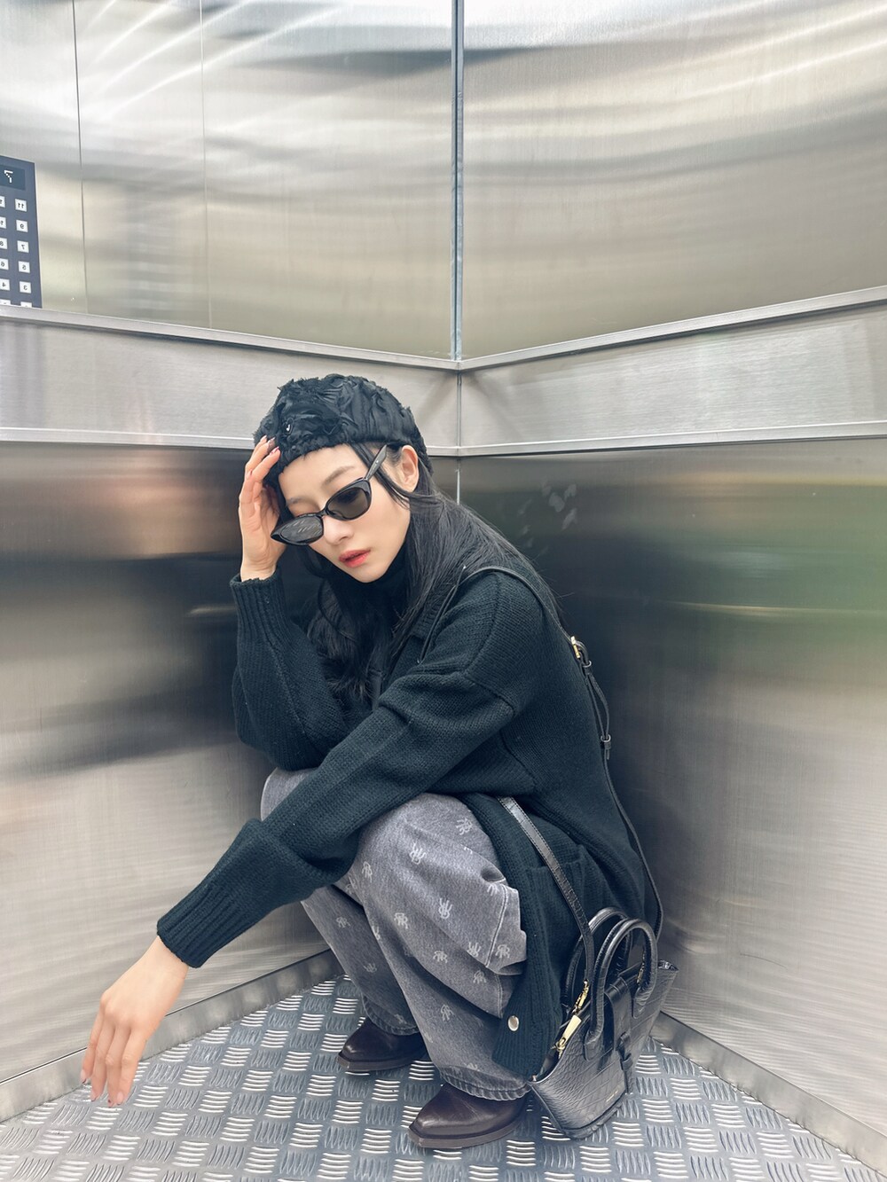 ブラック系のニット/セーターを着用したレディースの春コーディネートの2枚目の写真