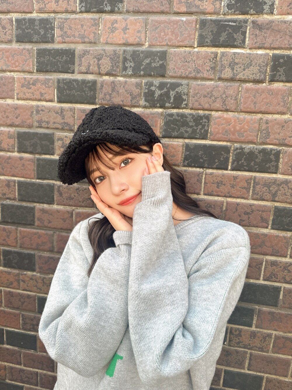 グレー系のニット/セーター、ブラック系のキャップを着用したレディースの秋コーディネートの4枚目の写真