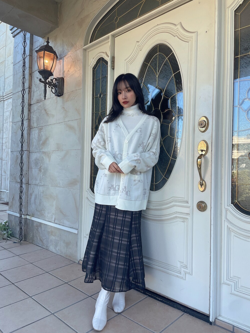 ブラック系のワンピース、ホワイト系のニット/セーターを着用したレディースの春コーディネートの3枚目の写真